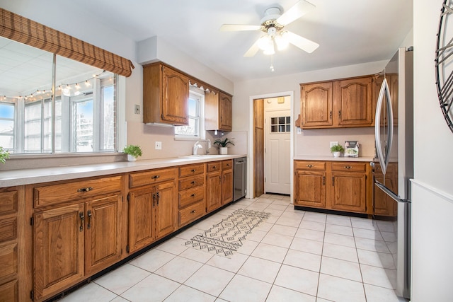 kitchen featuring appliances with stainless steel finishes, light countertops, brown cabinets, and light tile patterned floors