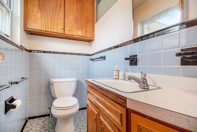 half bath featuring toilet, tile walls, and vanity