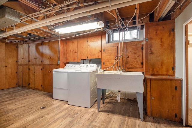 laundry area featuring washer and dryer, laundry area, wood walls, and light wood-style flooring