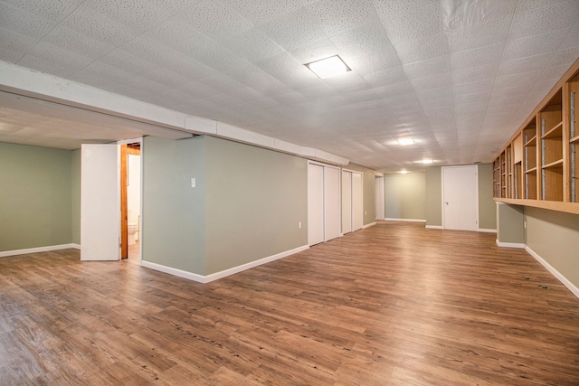 finished basement with baseboards and wood finished floors