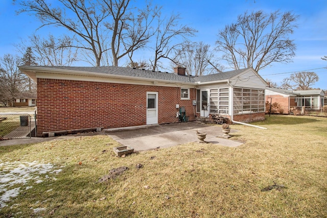 rear view of property with a patio, brick siding, fence, a lawn, and a chimney