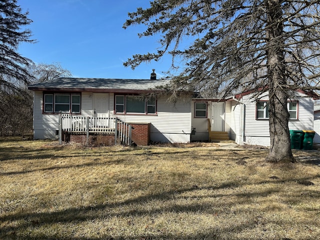 rear view of property featuring a lawn, roof with shingles, and entry steps