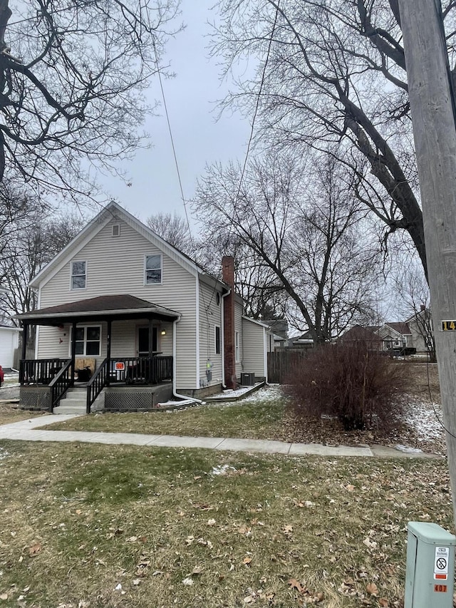 view of front of home featuring covered porch, a front lawn, and central air condition unit