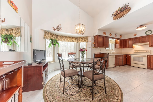 tiled dining area featuring high vaulted ceiling, sink, and an inviting chandelier