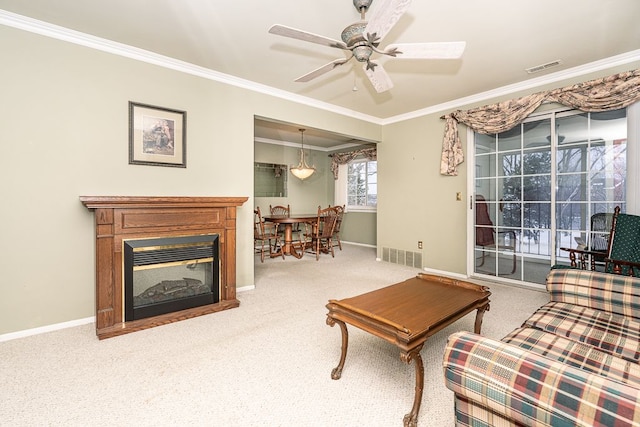 living room with ceiling fan, ornamental molding, and carpet