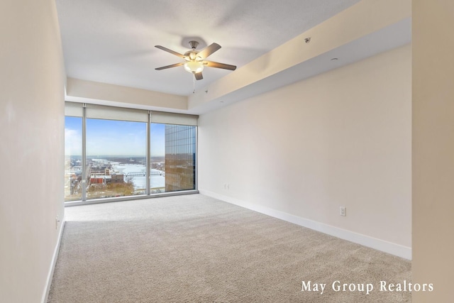 carpeted spare room featuring ceiling fan