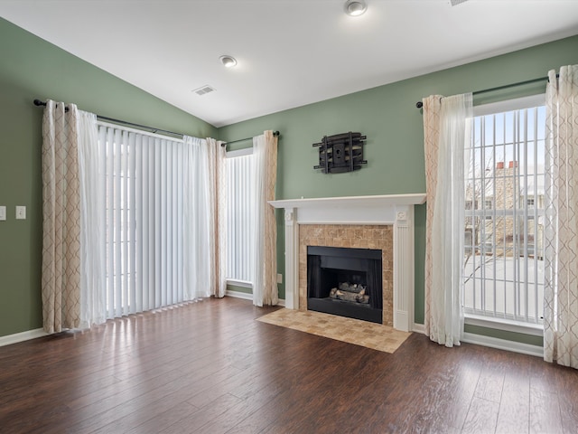 unfurnished living room featuring hardwood / wood-style flooring, lofted ceiling, and a fireplace