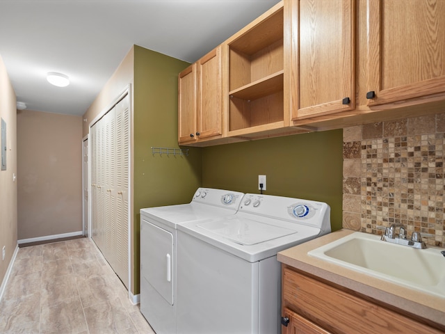 washroom with sink, cabinets, and independent washer and dryer