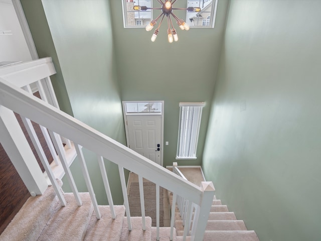 stairs featuring carpet flooring and a towering ceiling