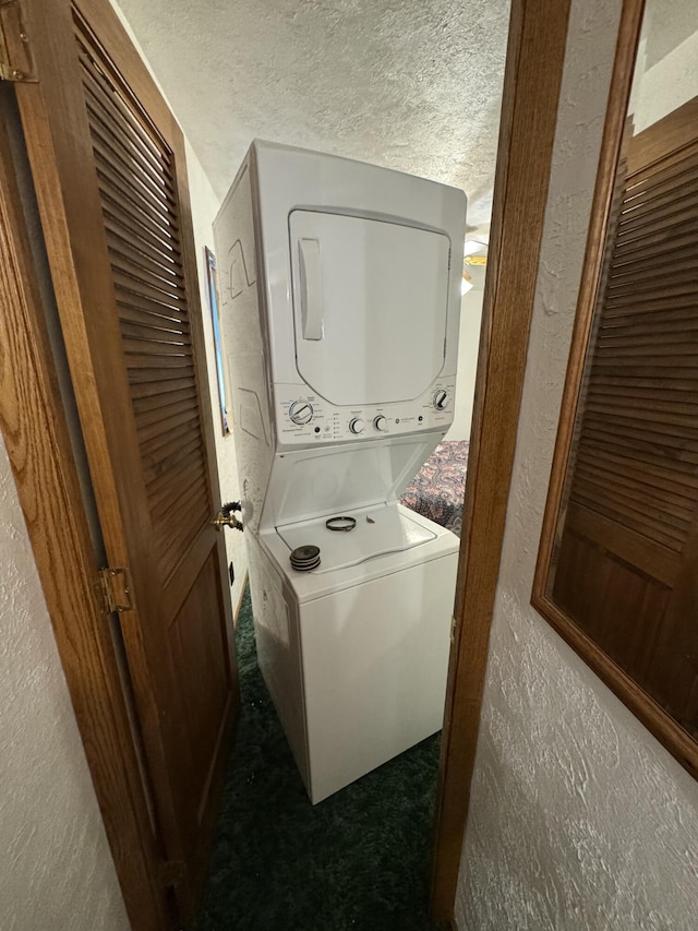 washroom featuring stacked washer / drying machine and a textured ceiling