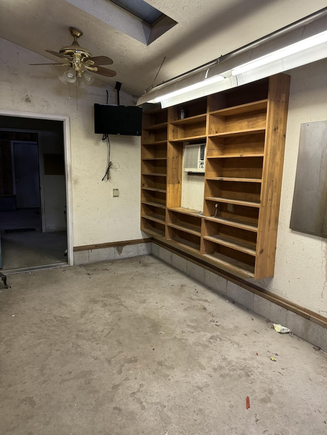 basement with ceiling fan and a textured ceiling