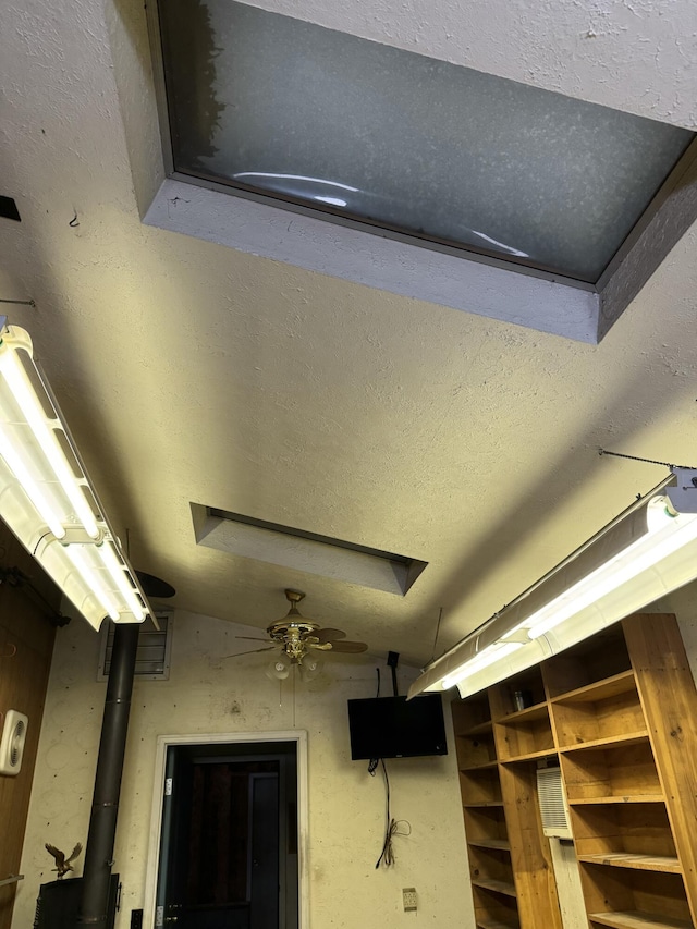 details with ceiling fan and a textured ceiling