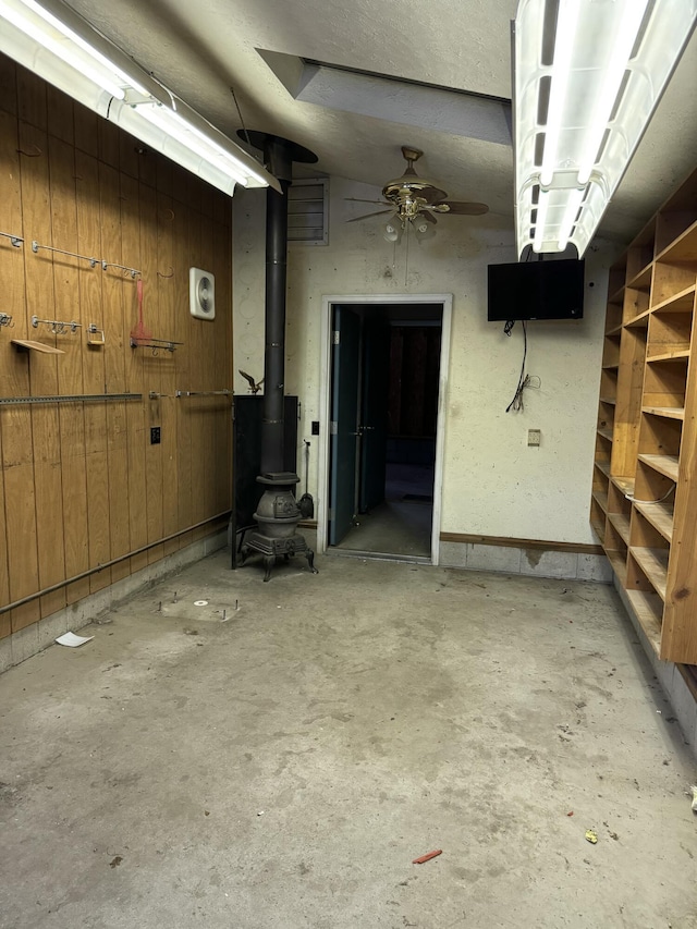 garage with a wood stove and wood walls