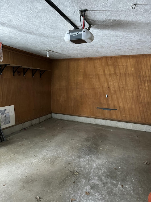 garage featuring a garage door opener and wooden walls