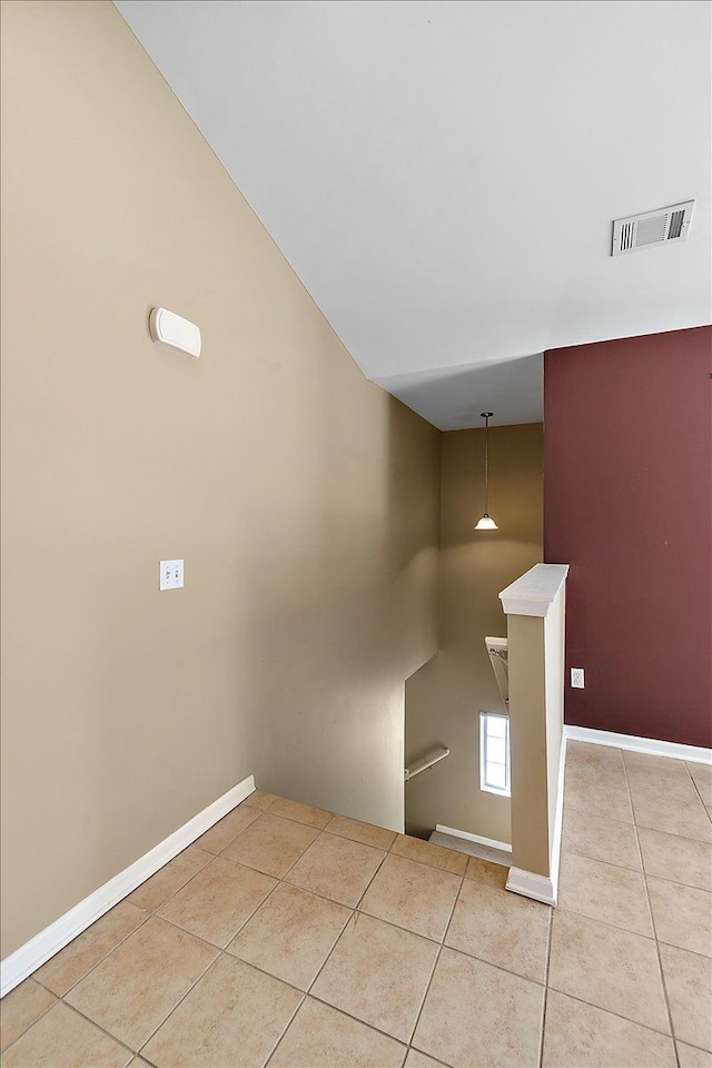 staircase featuring vaulted ceiling and tile patterned flooring