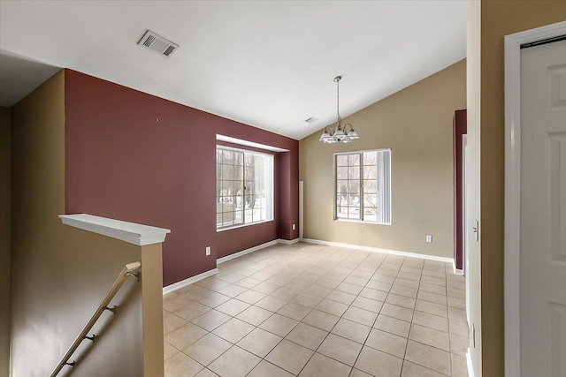 tiled spare room with lofted ceiling and a notable chandelier