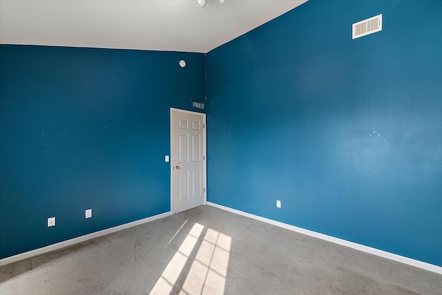 empty room with high vaulted ceiling and carpet floors