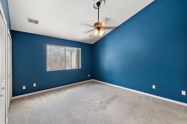 carpeted spare room with vaulted ceiling and ceiling fan