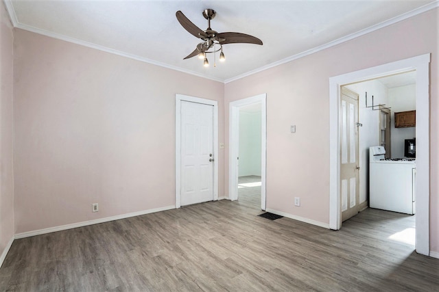 spare room with crown molding, washer / dryer, light hardwood / wood-style floors, and ceiling fan