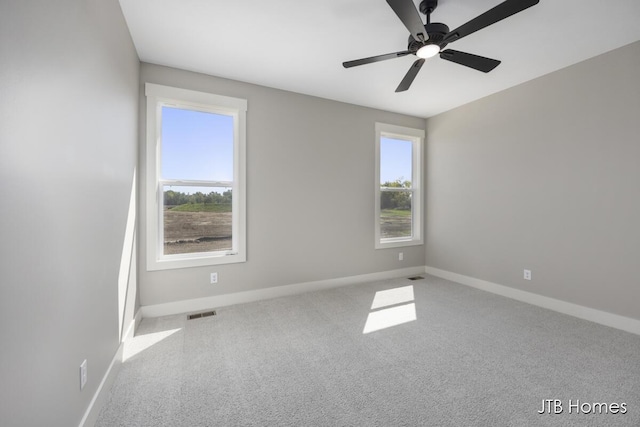 empty room featuring ceiling fan, a healthy amount of sunlight, and carpet flooring