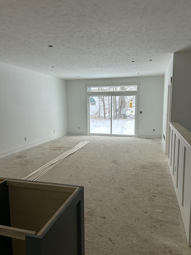 carpeted empty room featuring a textured ceiling