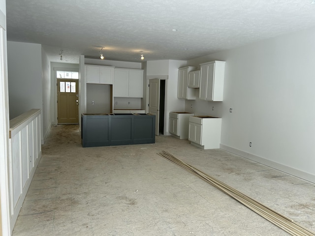 kitchen featuring a center island, white cabinets, and a textured ceiling