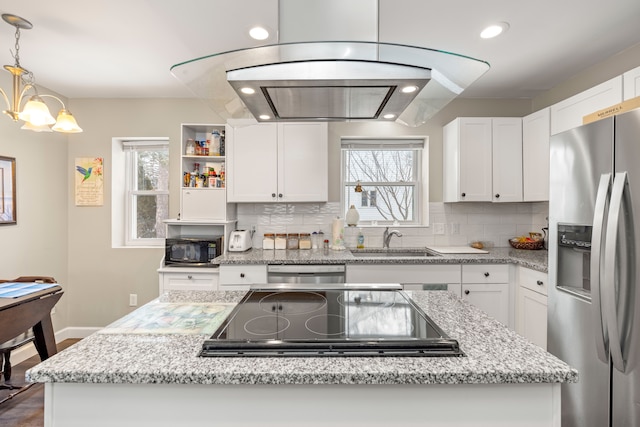 kitchen featuring white cabinetry, sink, decorative light fixtures, and black appliances