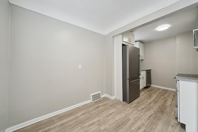 kitchen featuring appliances with stainless steel finishes, light wood-type flooring, and white cabinets