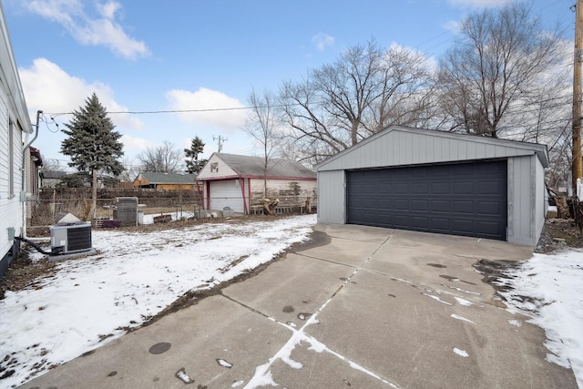 snow covered garage featuring central air condition unit