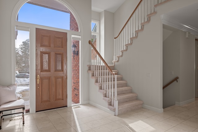 entrance foyer featuring a high ceiling and light tile patterned flooring