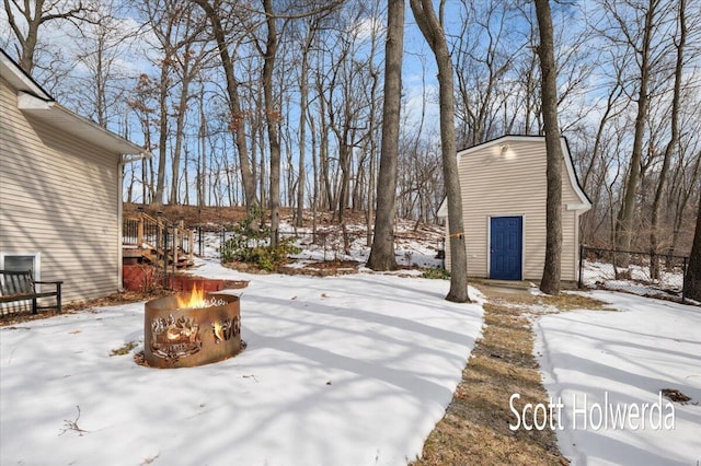 yard layered in snow with an outdoor fire pit