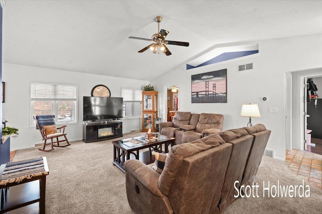 carpeted living room with ceiling fan and vaulted ceiling