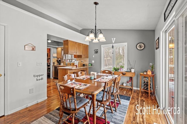 dining area with lofted ceiling, dark wood-type flooring, and a chandelier