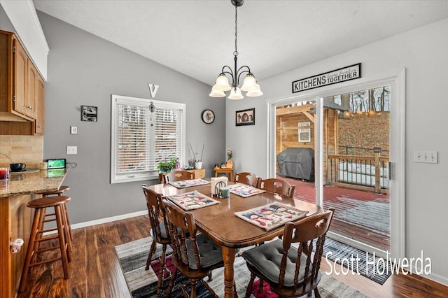 dining room featuring lofted ceiling, an inviting chandelier, and dark hardwood / wood-style flooring