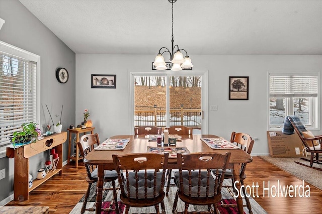 dining space with wood-type flooring and a chandelier