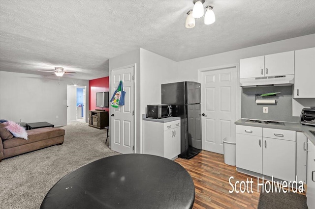 kitchen featuring hardwood / wood-style floors, white cabinetry, ceiling fan, black appliances, and a textured ceiling