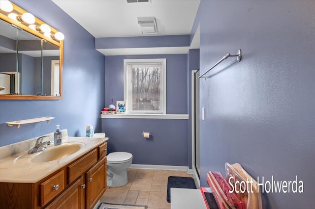 bathroom featuring vanity, toilet, an enclosed shower, and tile patterned flooring