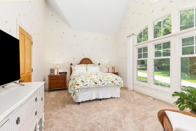 bedroom with light carpet and high vaulted ceiling