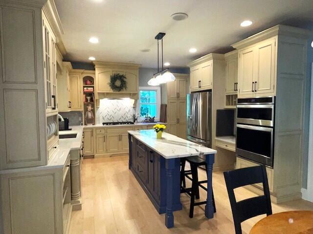 6352 Ryan Ridge Dr, Holland, MI 49423 - kitchen featuring stainless steel appliances, light countertops, a breakfast bar area, a center island, and recessed lighting