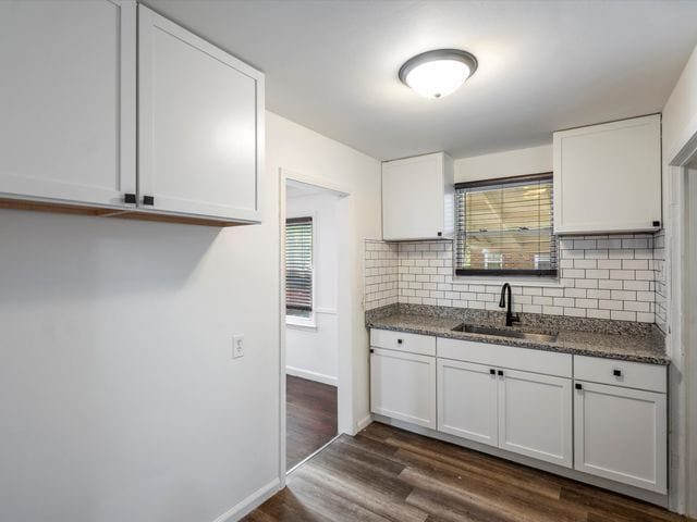 kitchen featuring white cabinetry, sink, tasteful backsplash, and dark hardwood / wood-style floors