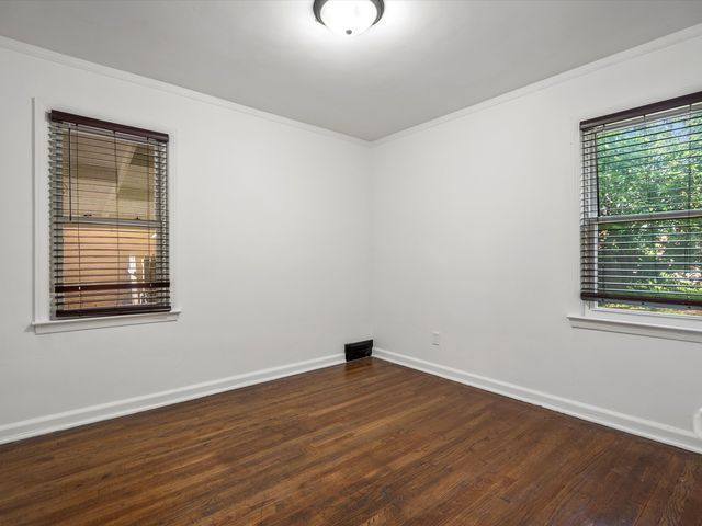 empty room with crown molding and dark hardwood / wood-style floors