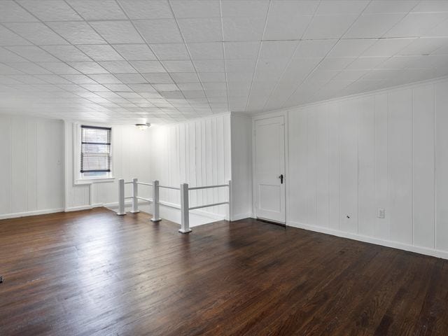 unfurnished room with dark wood-type flooring