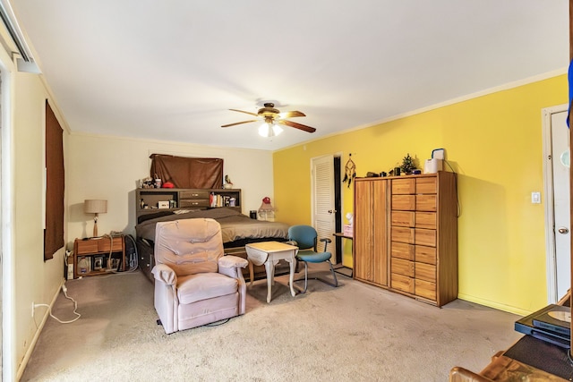 bedroom featuring crown molding, ceiling fan, a closet, and light carpet