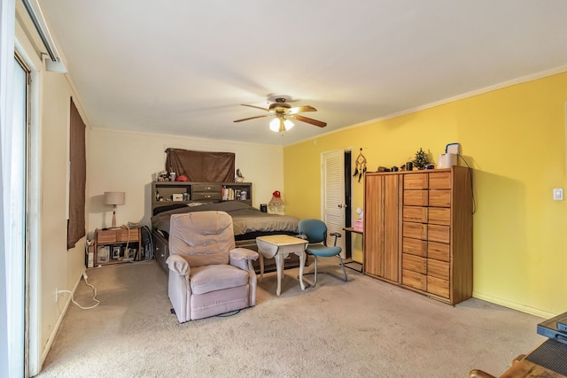 carpeted bedroom with ornamental molding, ceiling fan, and a closet