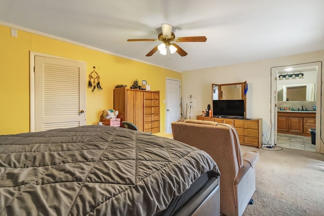 carpeted bedroom featuring connected bathroom and ceiling fan