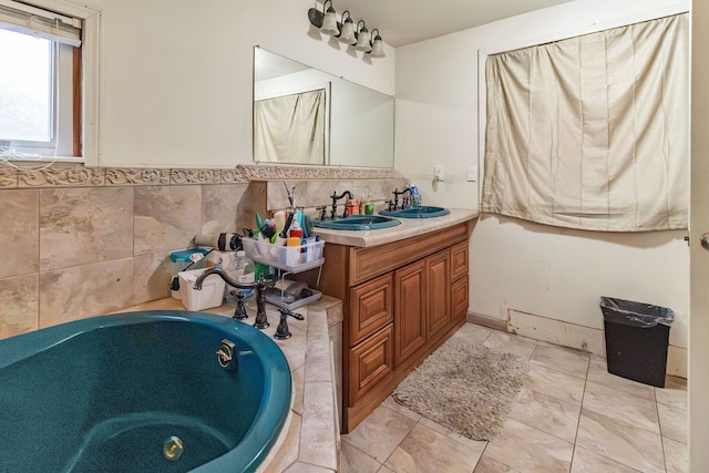 bathroom featuring vanity, a tub, and tile walls