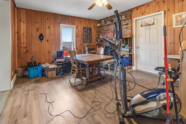 office space featuring ceiling fan, light hardwood / wood-style floors, and wood walls