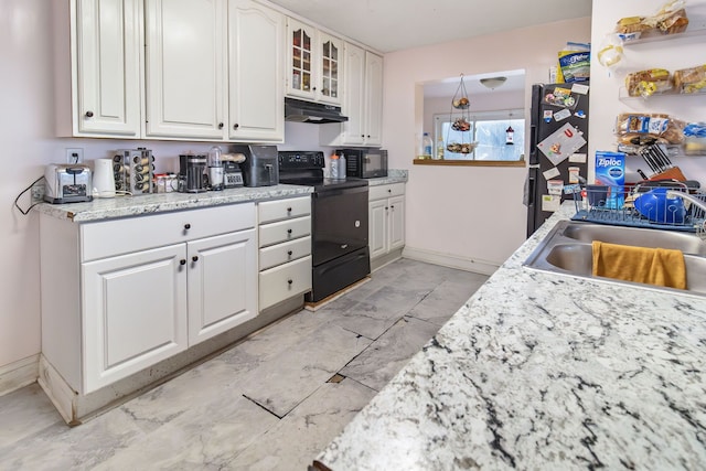 kitchen with white cabinetry, sink, light stone counters, and black appliances