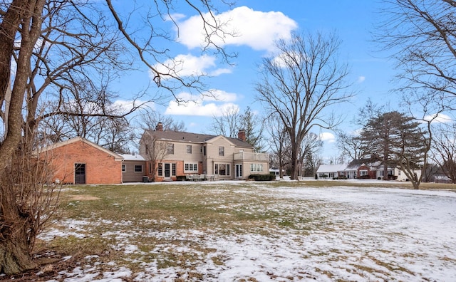 view of snow covered back of property