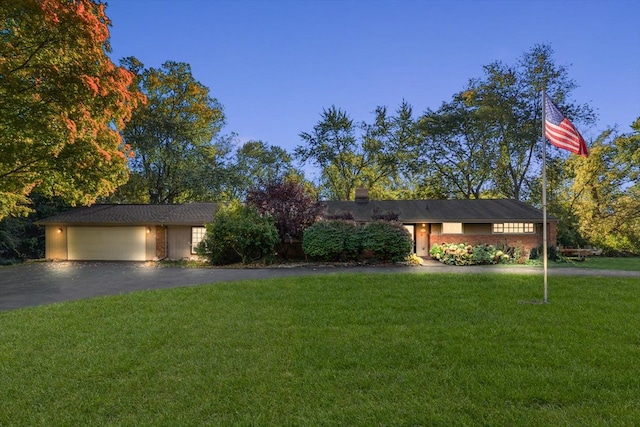 view of front of home featuring a garage and a yard